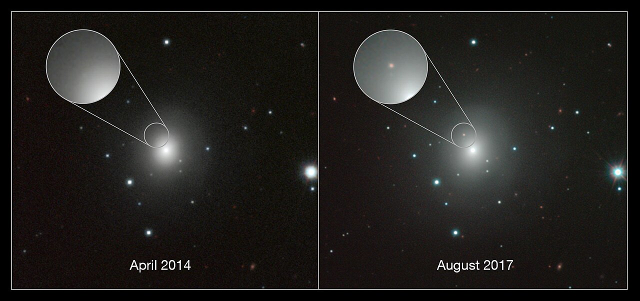 Two side-by-side telescope views of the same fuzzy, glowing galaxy among scattered stars on a black sky. In the left panel, labeled April 2014, a magnified circle near the galaxy’s bright center shows only smooth glow. In the right panel, labeled August 2017, the same magnified spot shows a small new reddish dot.