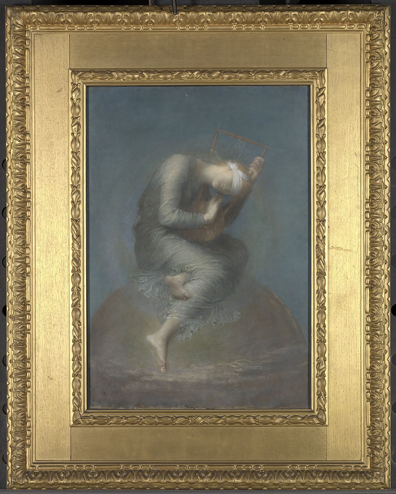 A painting in a wide gold frame of a barefoot woman in a pale, flowing gown, blindfolded with a white cloth, sitting hunched on top of a large brownish globe against a blue-gray background. She bends her head close to a small wooden lyre whose strings mostly hang loose.