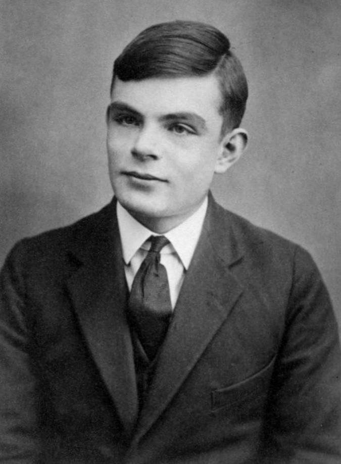 Black-and-white portrait of a teenage boy with neatly combed dark hair, wearing a dark suit jacket, white shirt and dark tie, looking slightly to the side.